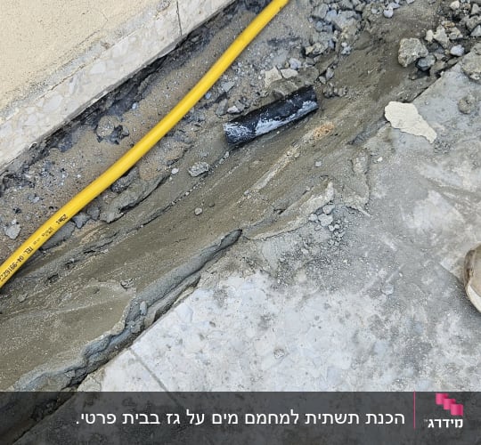 הנחת צינור גז צהוב בתעלה חצובה ברצפה לאורך קיר